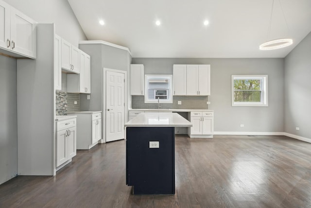 kitchen featuring white cabinets, backsplash, a kitchen island, and hanging light fixtures