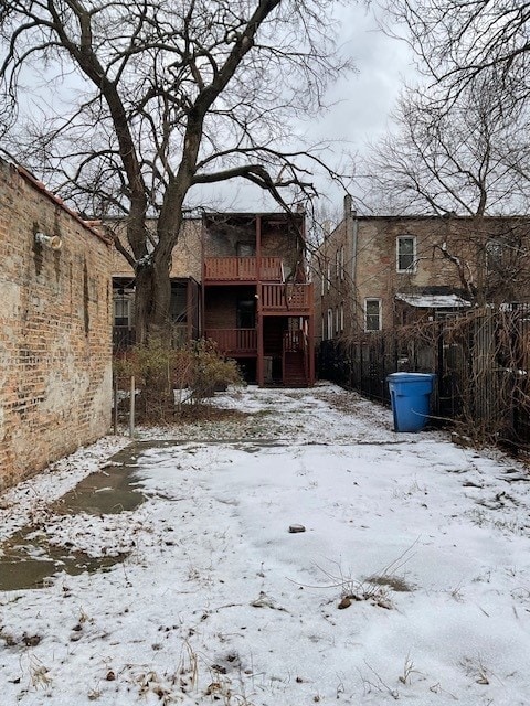 yard layered in snow with a deck