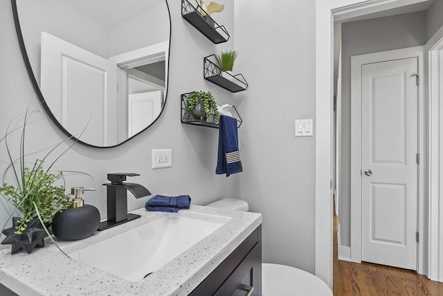 bathroom featuring vanity, hardwood / wood-style flooring, and toilet