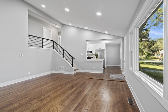 unfurnished living room featuring dark hardwood / wood-style floors and vaulted ceiling