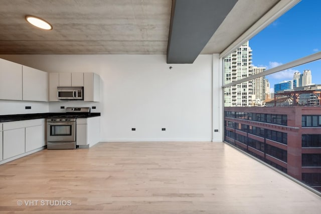 kitchen with white cabinetry, light hardwood / wood-style flooring, and stainless steel appliances