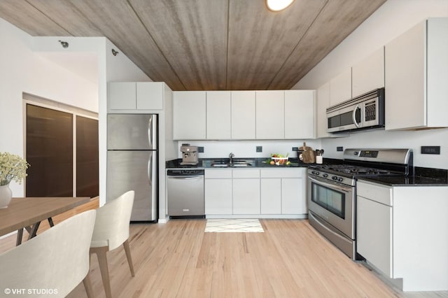 kitchen with appliances with stainless steel finishes, light hardwood / wood-style flooring, white cabinetry, and sink