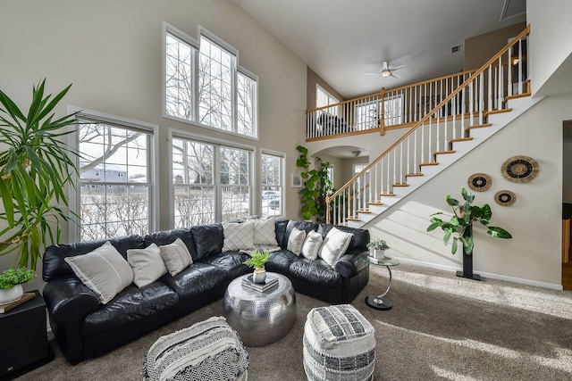 carpeted living room featuring a towering ceiling