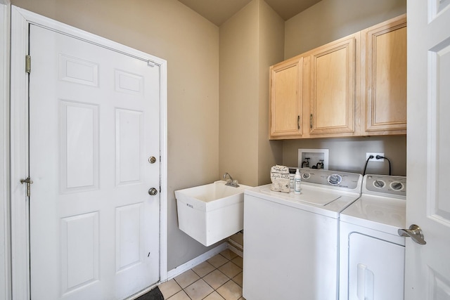 laundry area featuring sink, light tile patterned flooring, separate washer and dryer, and cabinets