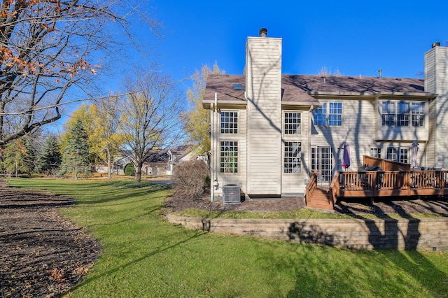 back of property featuring a wooden deck, a lawn, and central AC