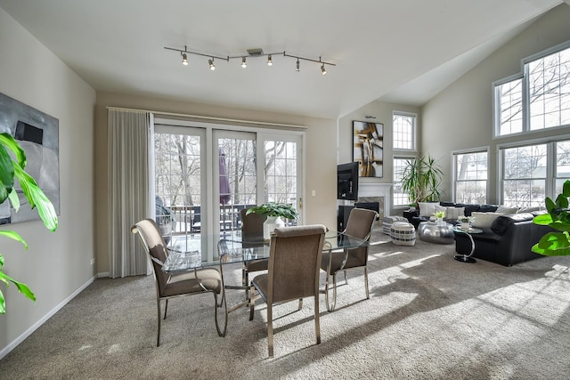 carpeted dining area with vaulted ceiling