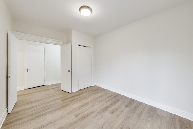 unfurnished bedroom with a closet and light hardwood / wood-style floors