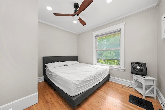 bedroom with hardwood / wood-style floors, ceiling fan, and crown molding