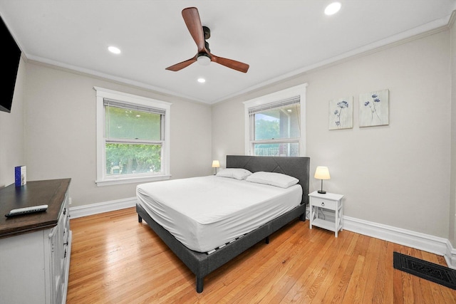 bedroom with ceiling fan, light hardwood / wood-style floors, and ornamental molding