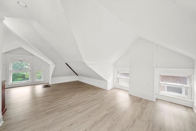 additional living space featuring light hardwood / wood-style floors and lofted ceiling