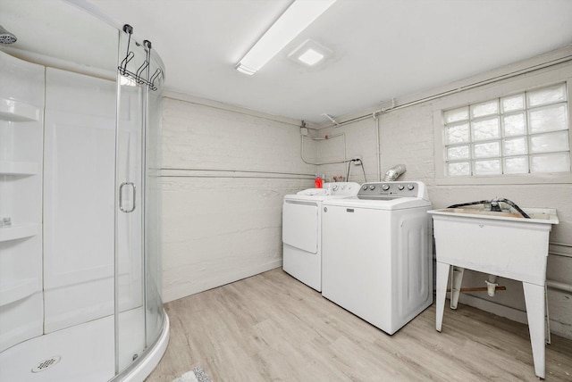 laundry room featuring washing machine and dryer and light hardwood / wood-style floors