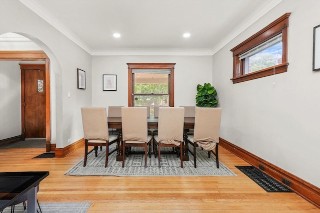 dining space featuring crown molding and hardwood / wood-style flooring