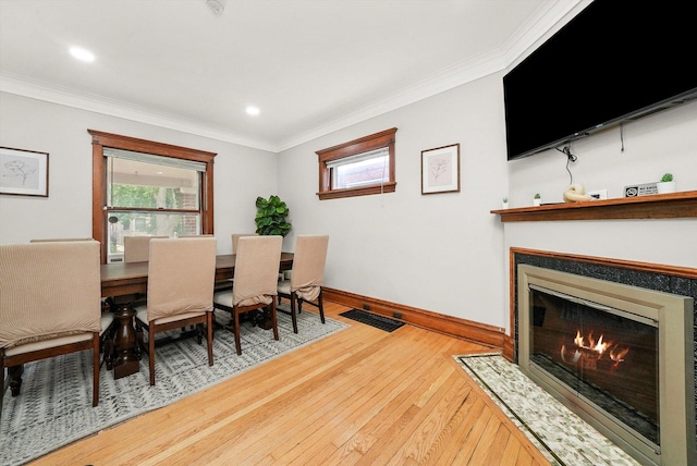 dining space with hardwood / wood-style flooring and ornamental molding