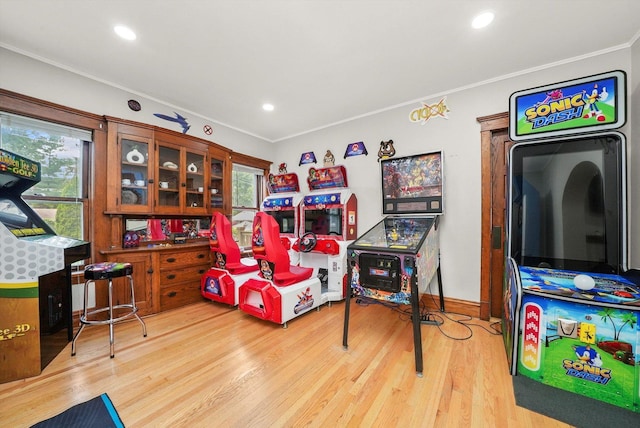 recreation room featuring plenty of natural light, light wood-type flooring, and crown molding