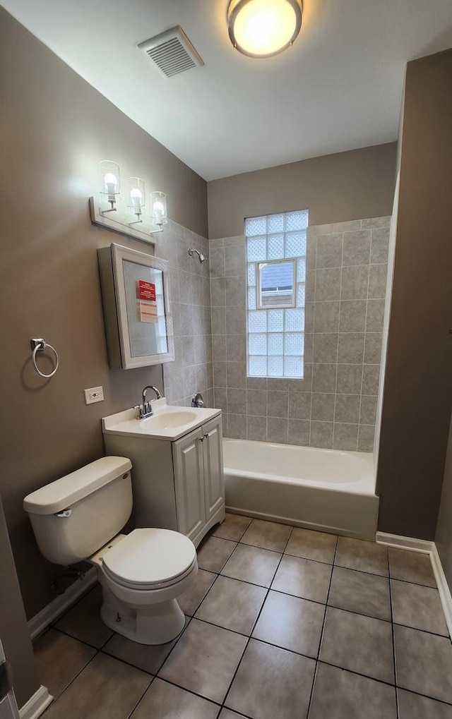 full bathroom featuring tile patterned flooring, vanity, toilet, and tiled shower / bath combo