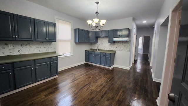 kitchen featuring sink, hanging light fixtures, dark hardwood / wood-style floors, and an inviting chandelier