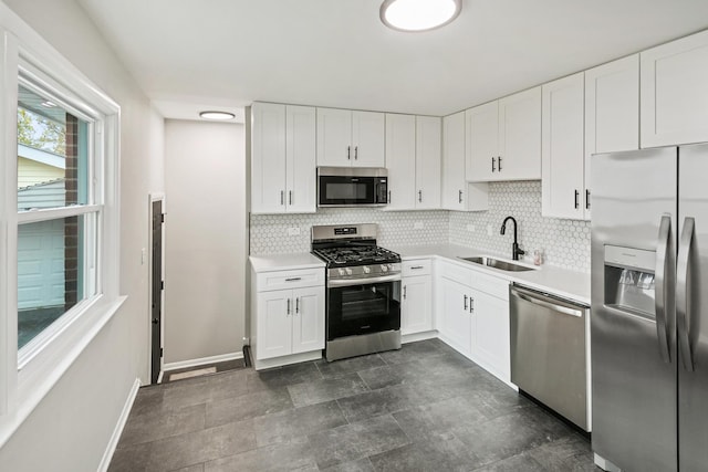 kitchen featuring decorative backsplash, stainless steel appliances, white cabinetry, and sink