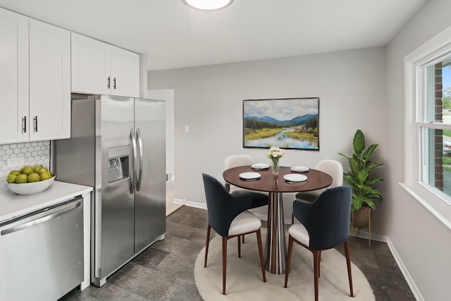 kitchen with white cabinets, decorative backsplash, and stainless steel appliances