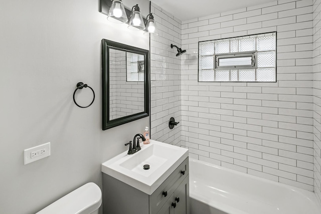 full bathroom featuring vanity, toilet, and tiled shower / bath