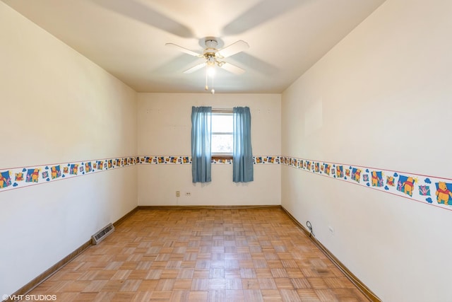 empty room with ceiling fan and light parquet flooring