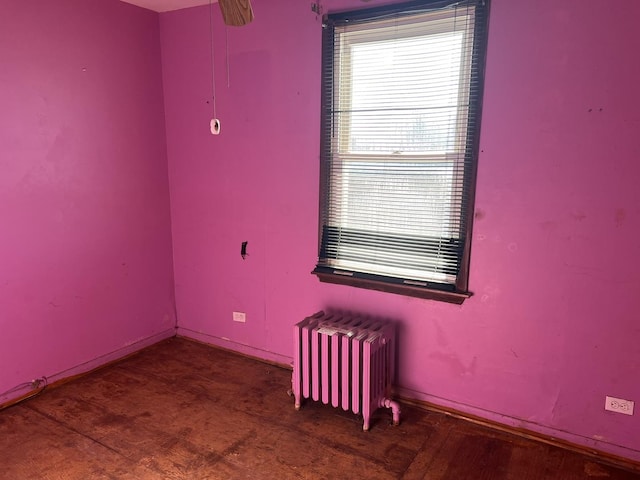 unfurnished room with radiator heating unit