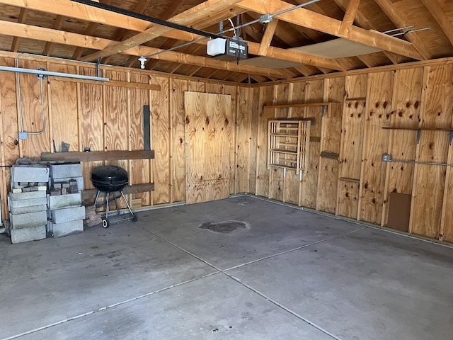 garage with wooden walls and a garage door opener