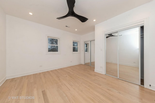 unfurnished bedroom featuring two closets, ceiling fan, and light hardwood / wood-style flooring