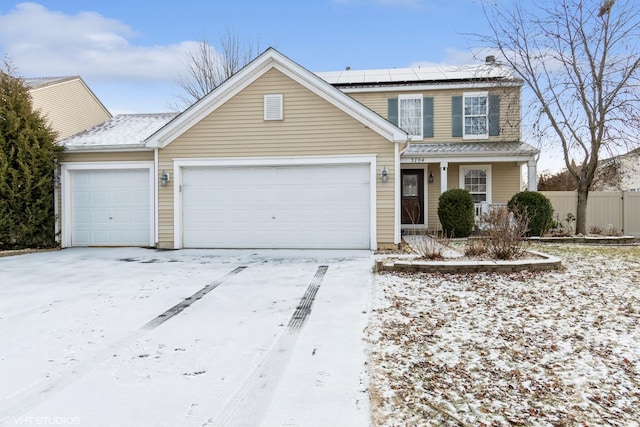 view of front property featuring a garage and solar panels