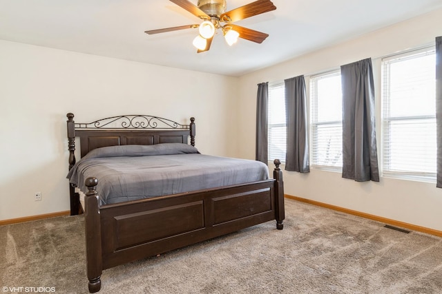 bedroom featuring multiple windows, ceiling fan, and light colored carpet