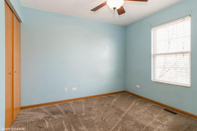 carpeted spare room featuring ceiling fan