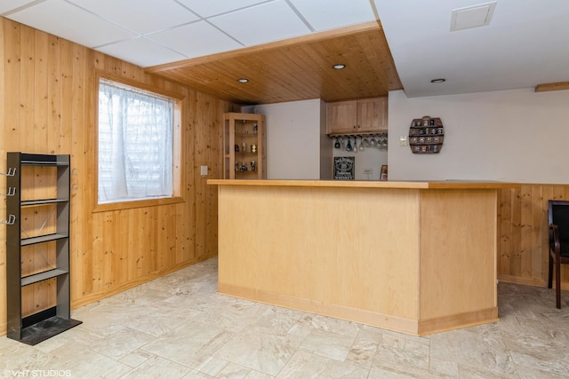 kitchen with wooden walls and light brown cabinetry