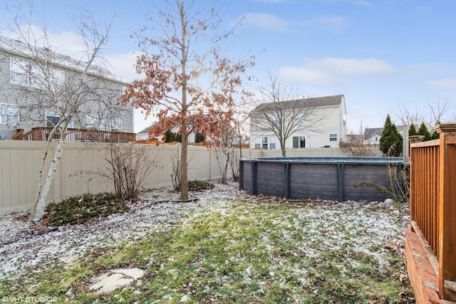 yard covered in snow with a fenced in pool