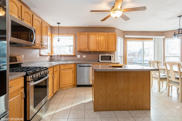 kitchen featuring sink, a kitchen island, pendant lighting, and appliances with stainless steel finishes