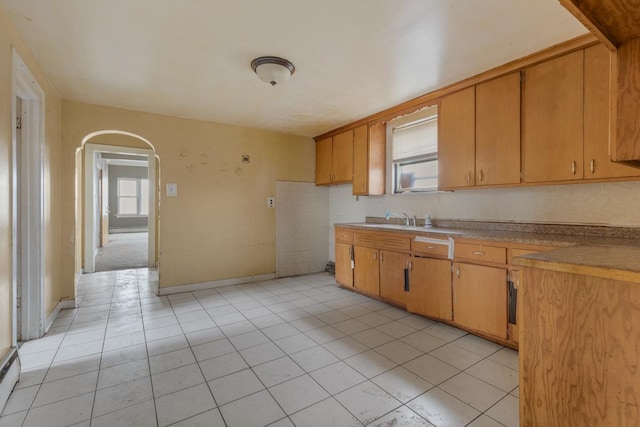 kitchen featuring light tile patterned flooring, tasteful backsplash, a baseboard heating unit, and sink