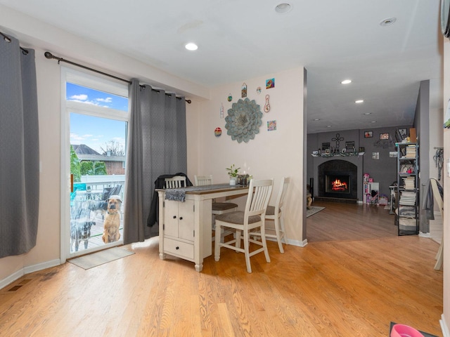 office with a large fireplace and light hardwood / wood-style floors