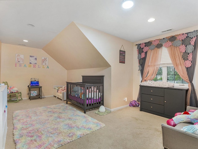 carpeted bedroom featuring a nursery area and lofted ceiling