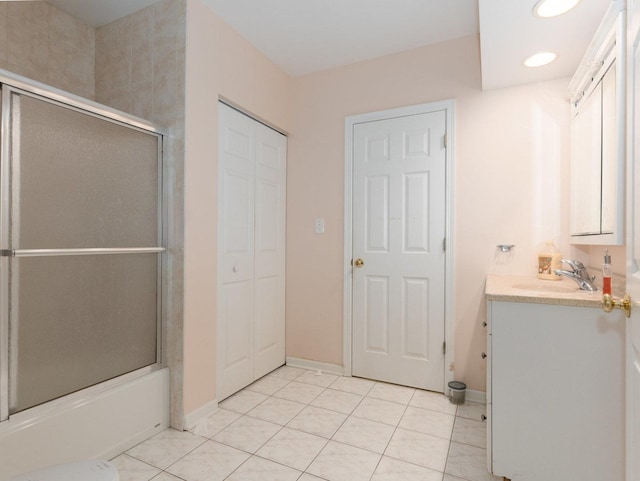 bathroom featuring tile patterned flooring, vanity, and enclosed tub / shower combo