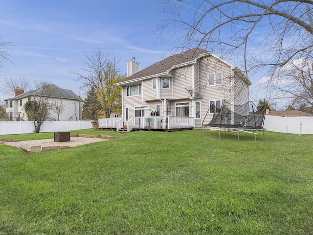 rear view of house featuring a patio, a yard, a trampoline, and a deck