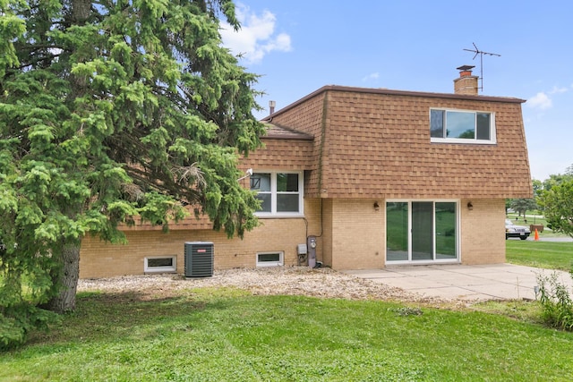 rear view of property featuring a patio, central AC unit, and a lawn