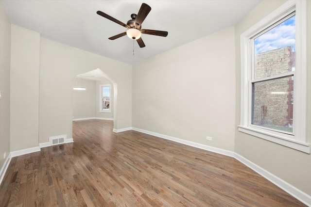 empty room featuring hardwood / wood-style floors, a wealth of natural light, and ceiling fan