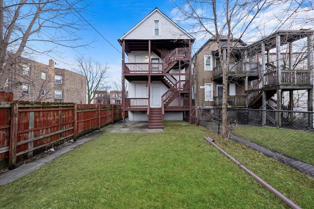 rear view of property with a lawn and a deck