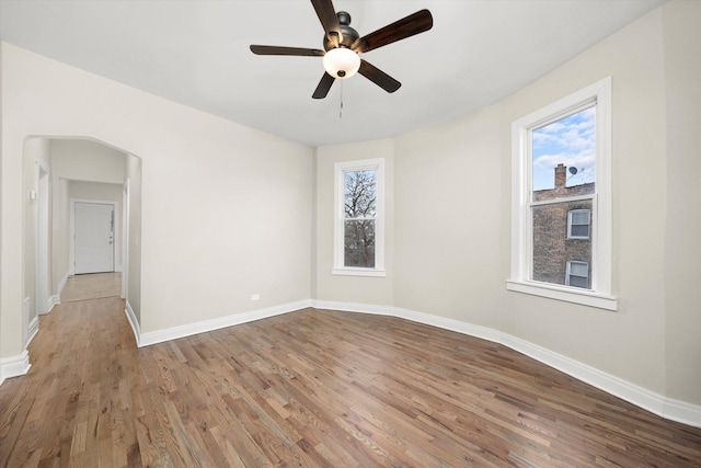 unfurnished room featuring ceiling fan, hardwood / wood-style floors, and plenty of natural light