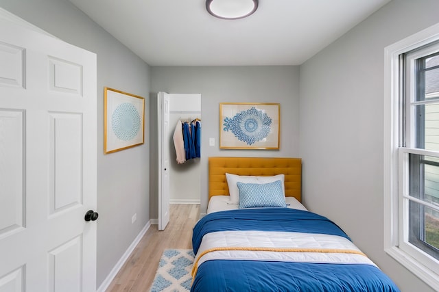 bedroom with light hardwood / wood-style floors and a closet