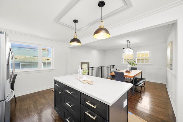 kitchen with a wealth of natural light, dark hardwood / wood-style flooring, stainless steel fridge, pendant lighting, and a kitchen island