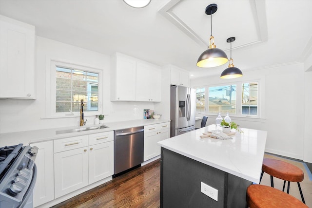 kitchen featuring dark wood-type flooring, white cabinets, sink, hanging light fixtures, and stainless steel appliances