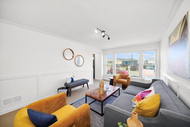 living room featuring track lighting and ornamental molding