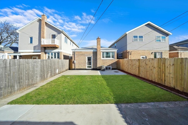 rear view of house featuring a lawn, central AC unit, and a patio