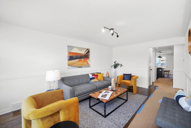 living room with track lighting, crown molding, and dark wood-type flooring