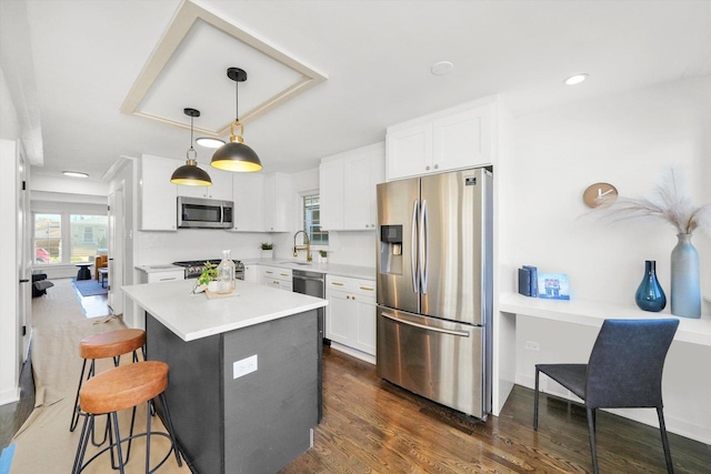 kitchen with white cabinetry, a center island, hanging light fixtures, and appliances with stainless steel finishes