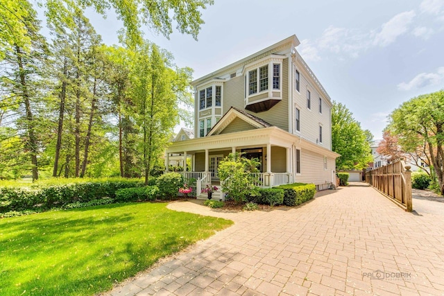 view of front of house with a porch, a garage, and a front yard